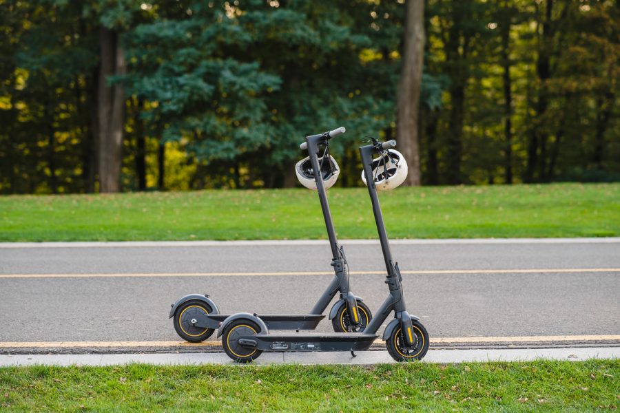 two electric kick scooters or e-scooter parked on the sidelines road