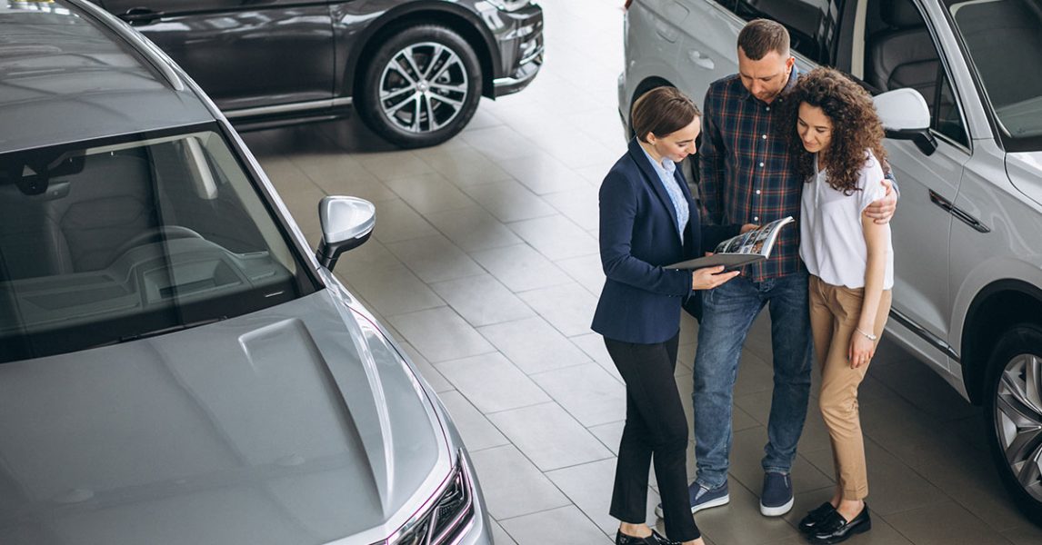 young-couple-talking-sales-person-car-showroom