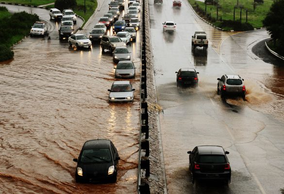 Motorists drive through water on a flooding highway